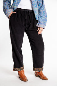 Susan is wearing the L/XL Ravi Sari Patch Fleece Pants in Black