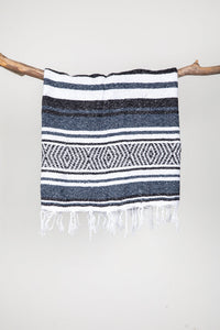 Woven recycled blanket with blue, white, and black pattern on a white background