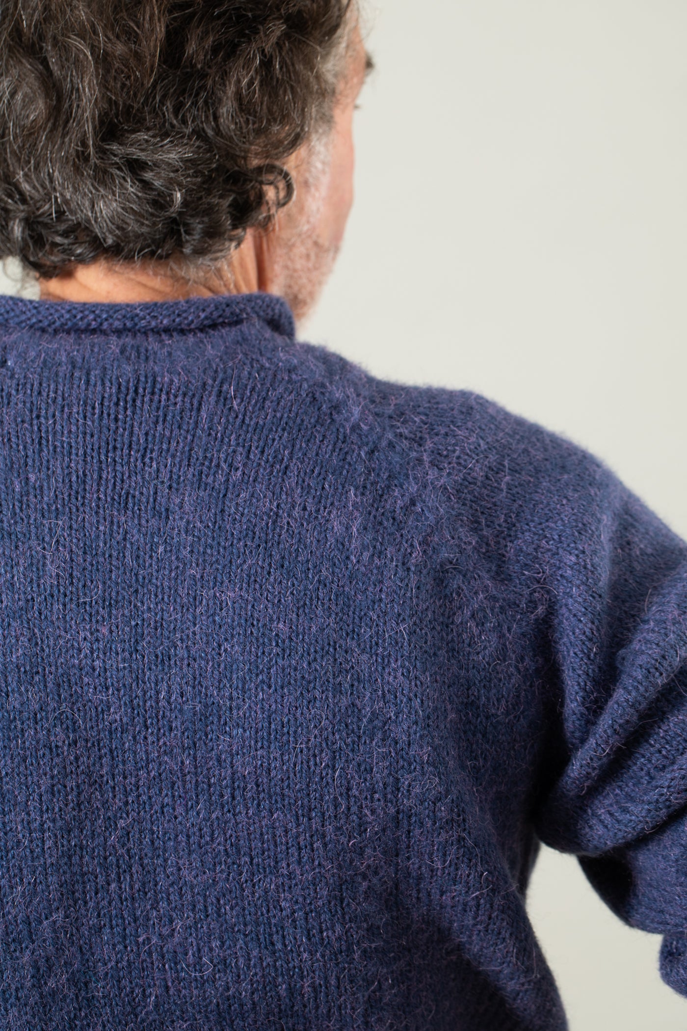 Bernie is wearing size L roll neck alpaca sweater in denim