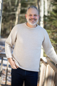 Michael is wearing size L roll neck alpaca sweater in oatmeal