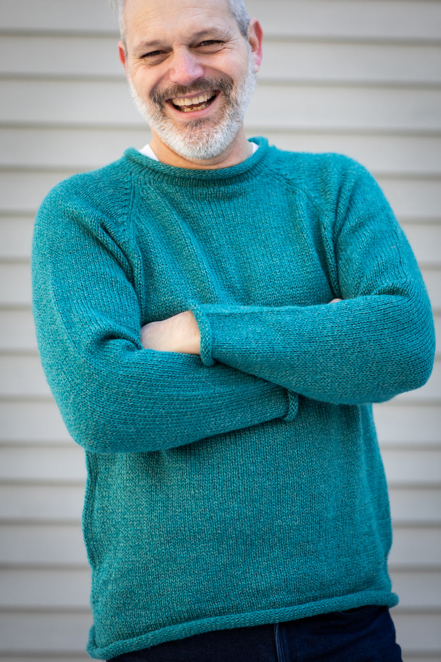 Michael wearing a size XL teal fisherman sweater with arms crossed against a neutral background