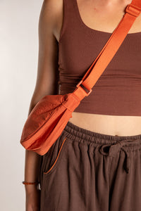 Emily is wearing the Samui Shoulder Bag in Rust 