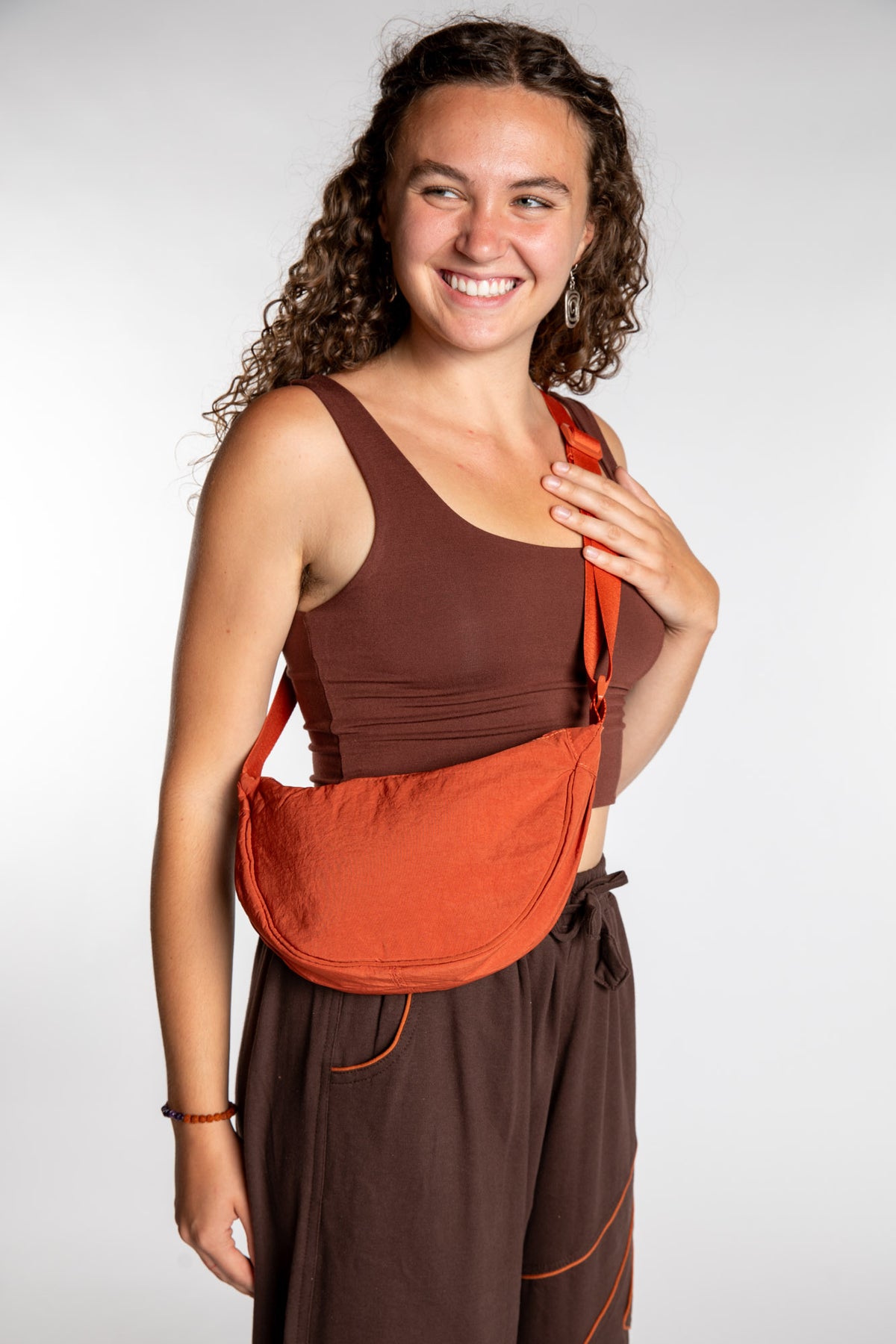 Emily is wearing the Samui Shoulder Bag in Rust 