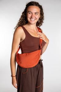 Emily is wearing the Samui Shoulder Bag in Rust 
