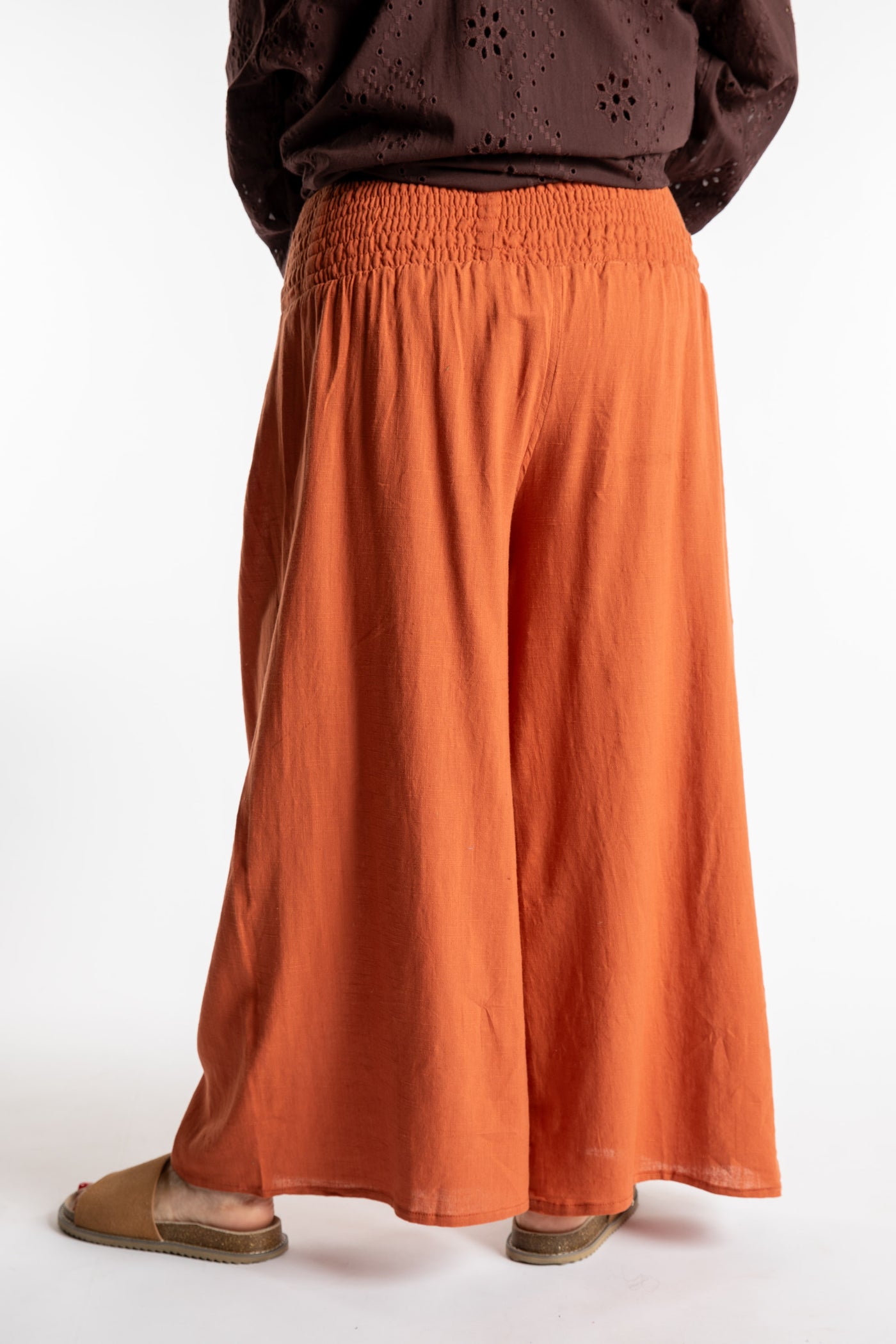 Betty is wearing the Saramati Palazzo Pants  in Terracotta in L/XL