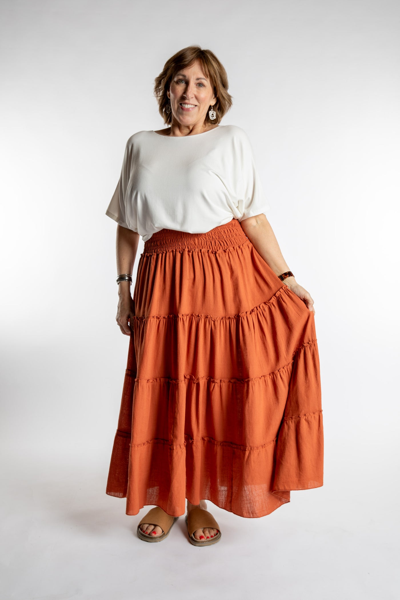 Betty is wearing the Saramati Prairie Skirt in one size in Terracotta