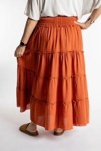 Betty is wearing the Saramati Prairie Skirt in one size in Terracotta