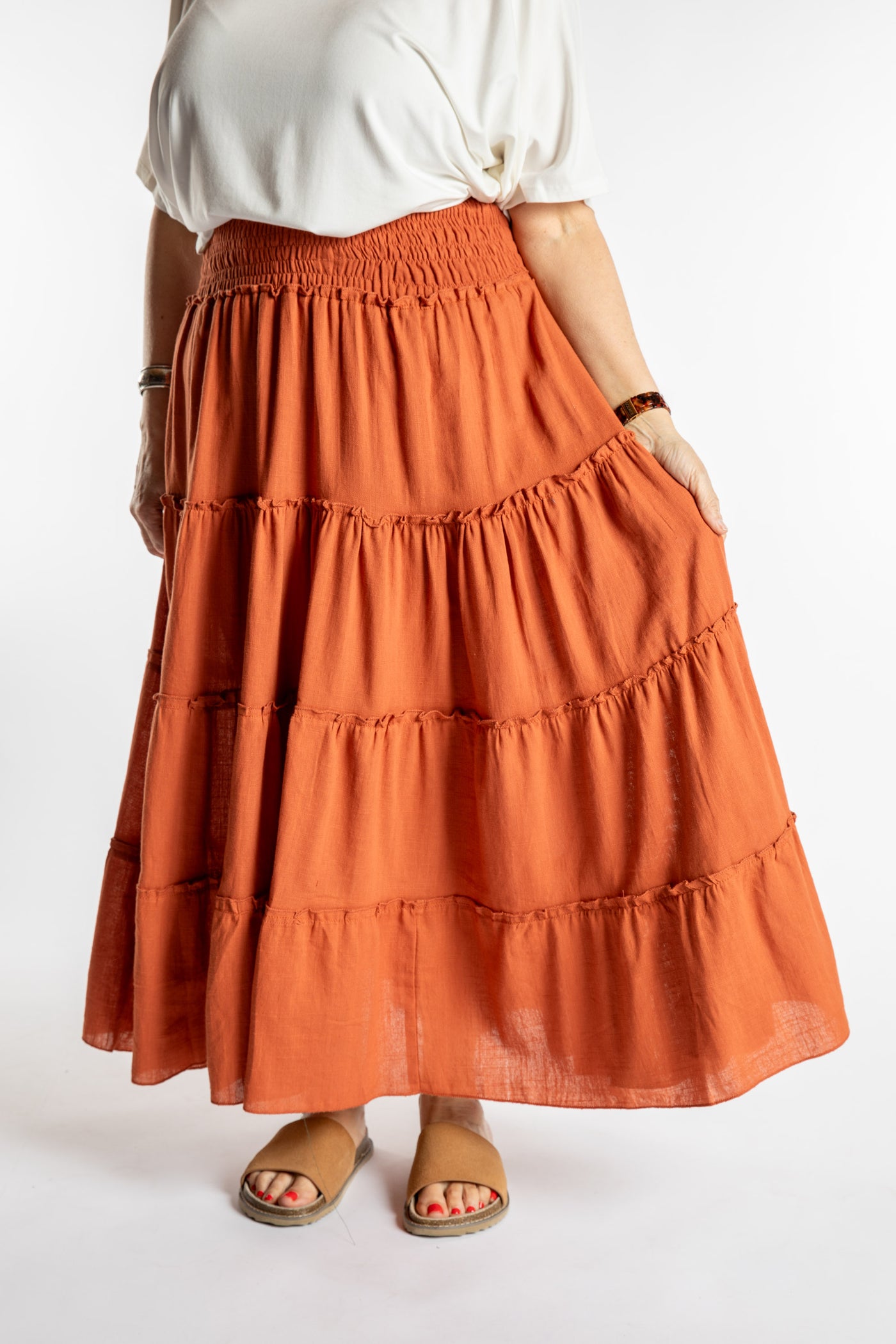 Betty is wearing the Saramati Prairie Skirt in one size in Terracotta