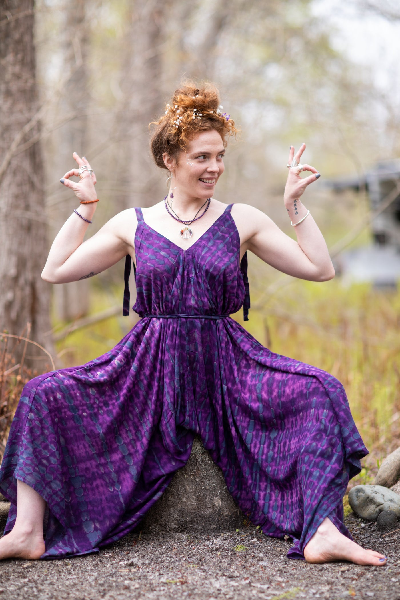 Carly is wearing a tie dye jumpsuit in purple