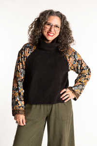 Susan is wearing the M/L Suhana Sari Patch Fleece Pullover in Black
