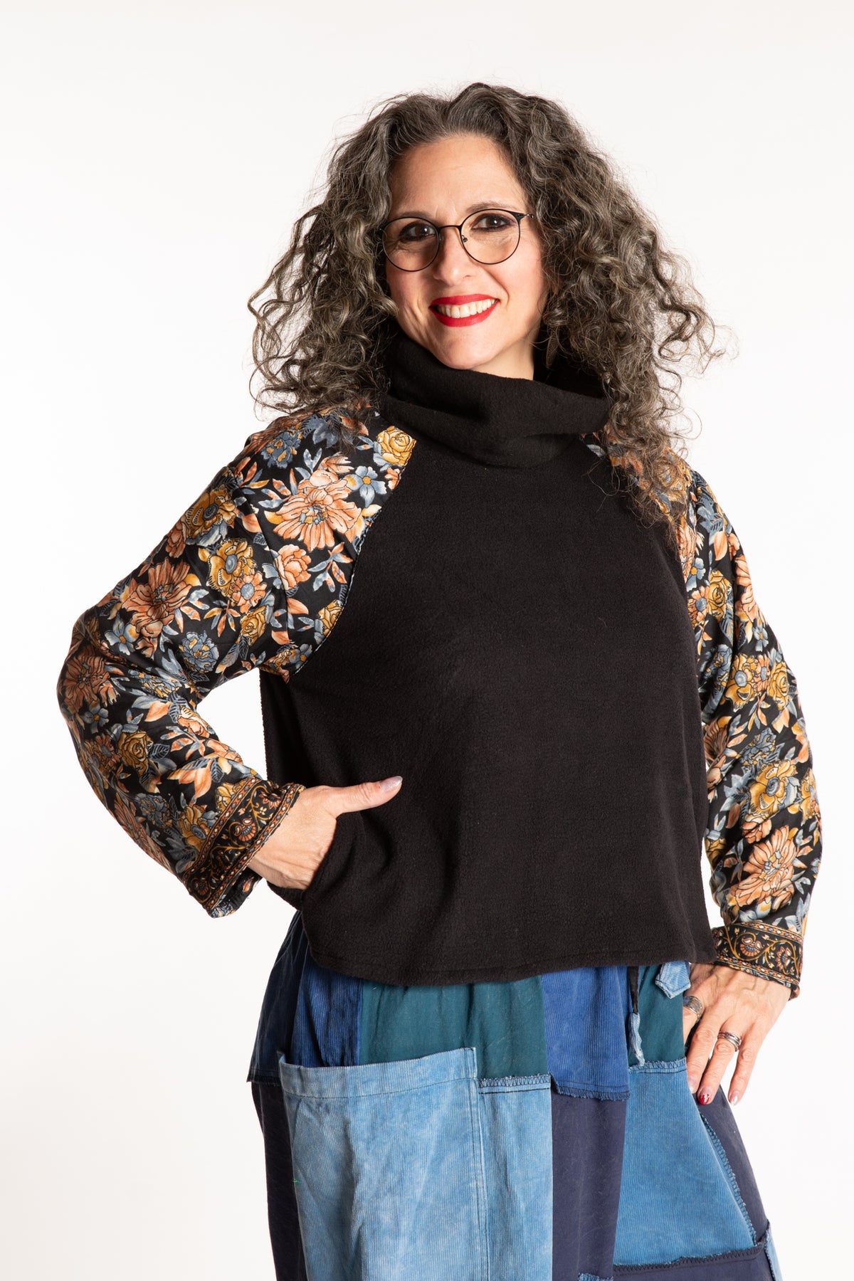 Susan is wearing the M/L Suhana Sari Patch Fleece Pullover in Black