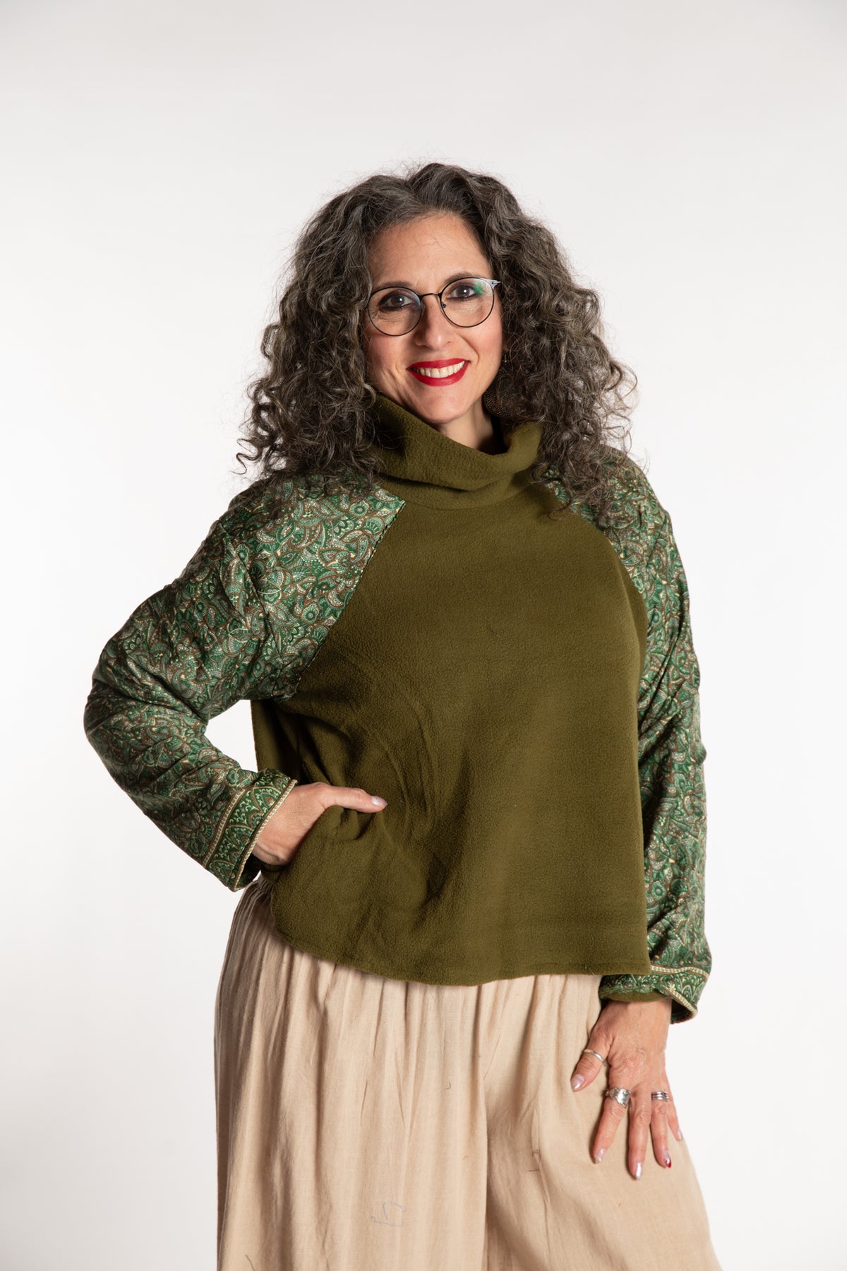 Susan is wearing the M/L Suhana Sari Patch Fleece Pullover in Green