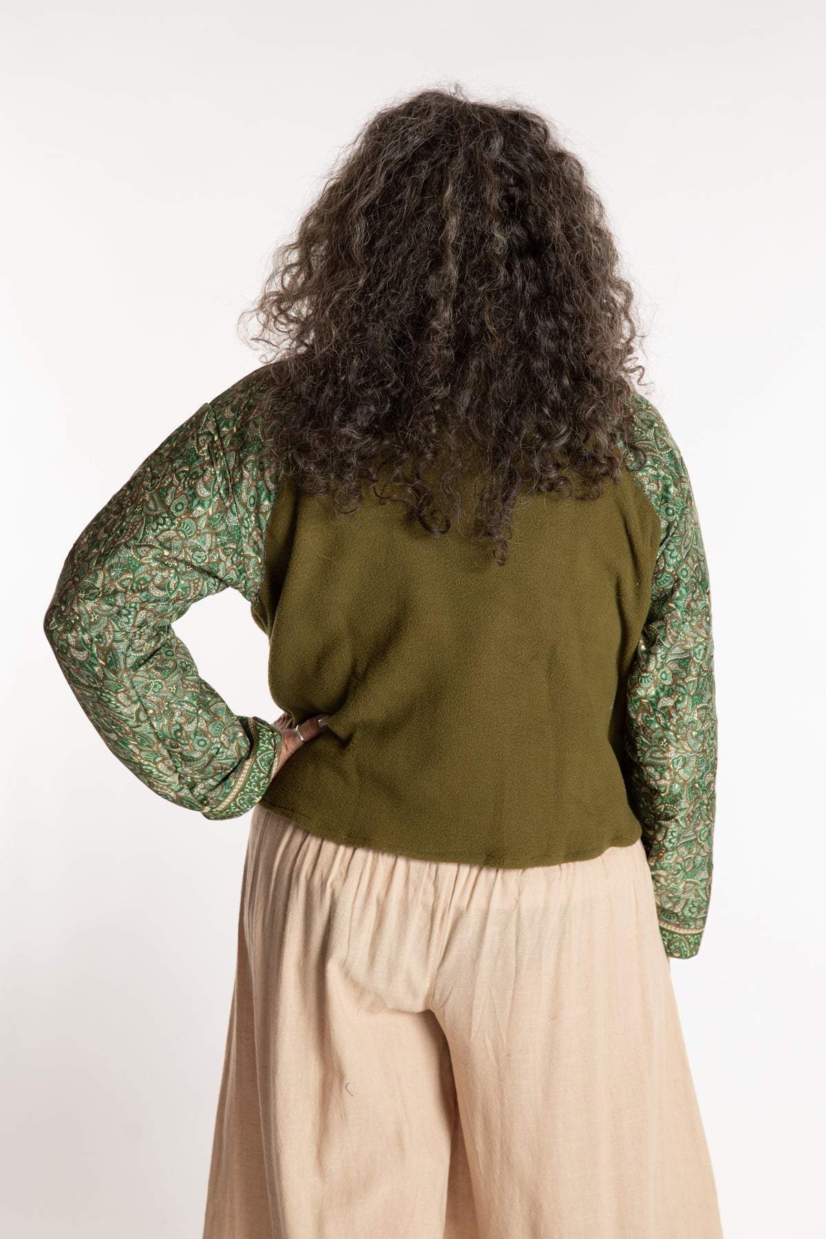 Susan is wearing the M/L Suhana Sari Patch Fleece Pullover in Green