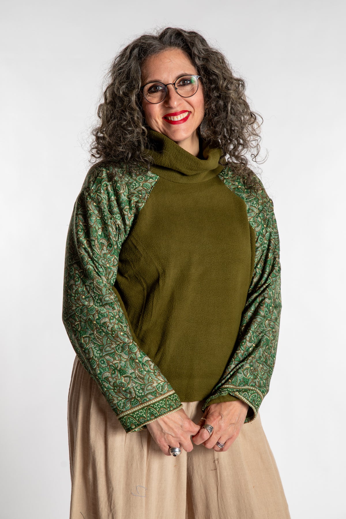 Susan is wearing the M/L Suhana Sari Patch Fleece Pullover in Green