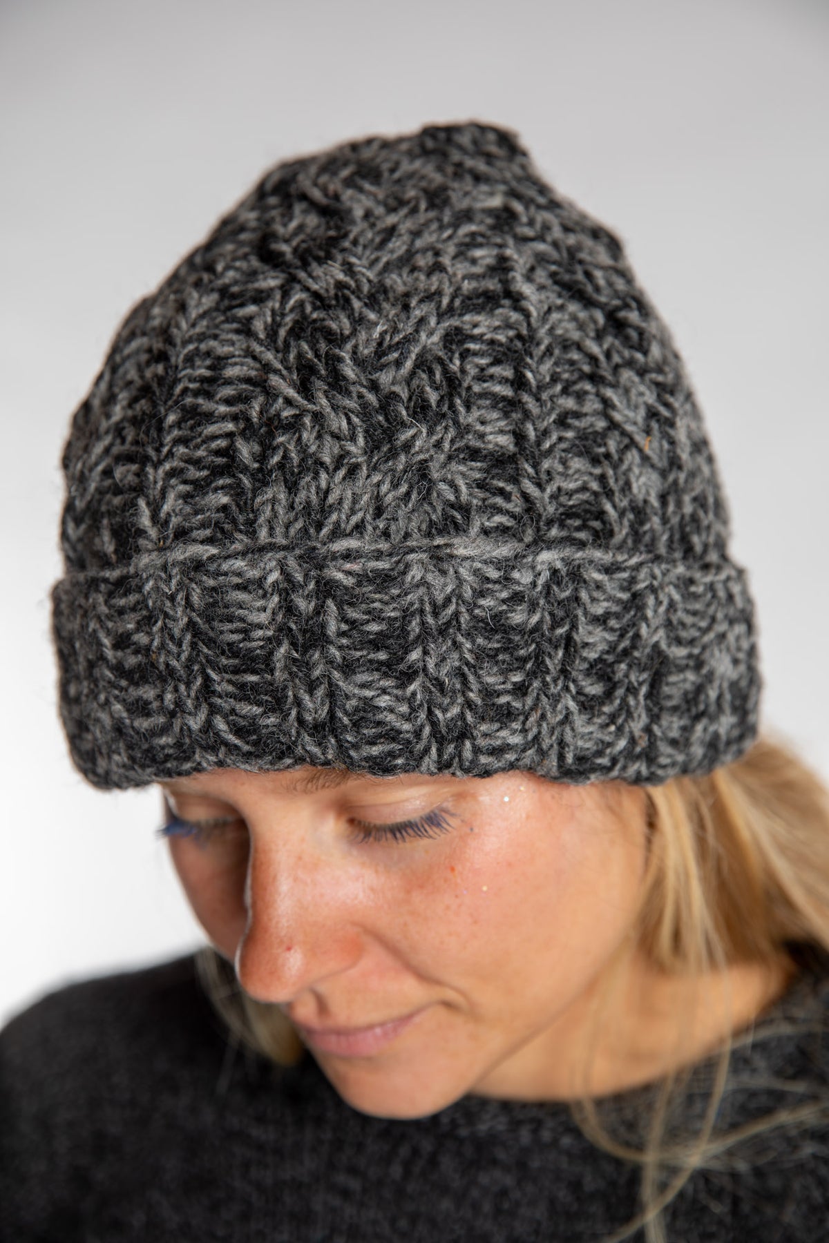 Sophie is wearing the Wharfside Cable Knit Wool Beanie in Black Space Dye