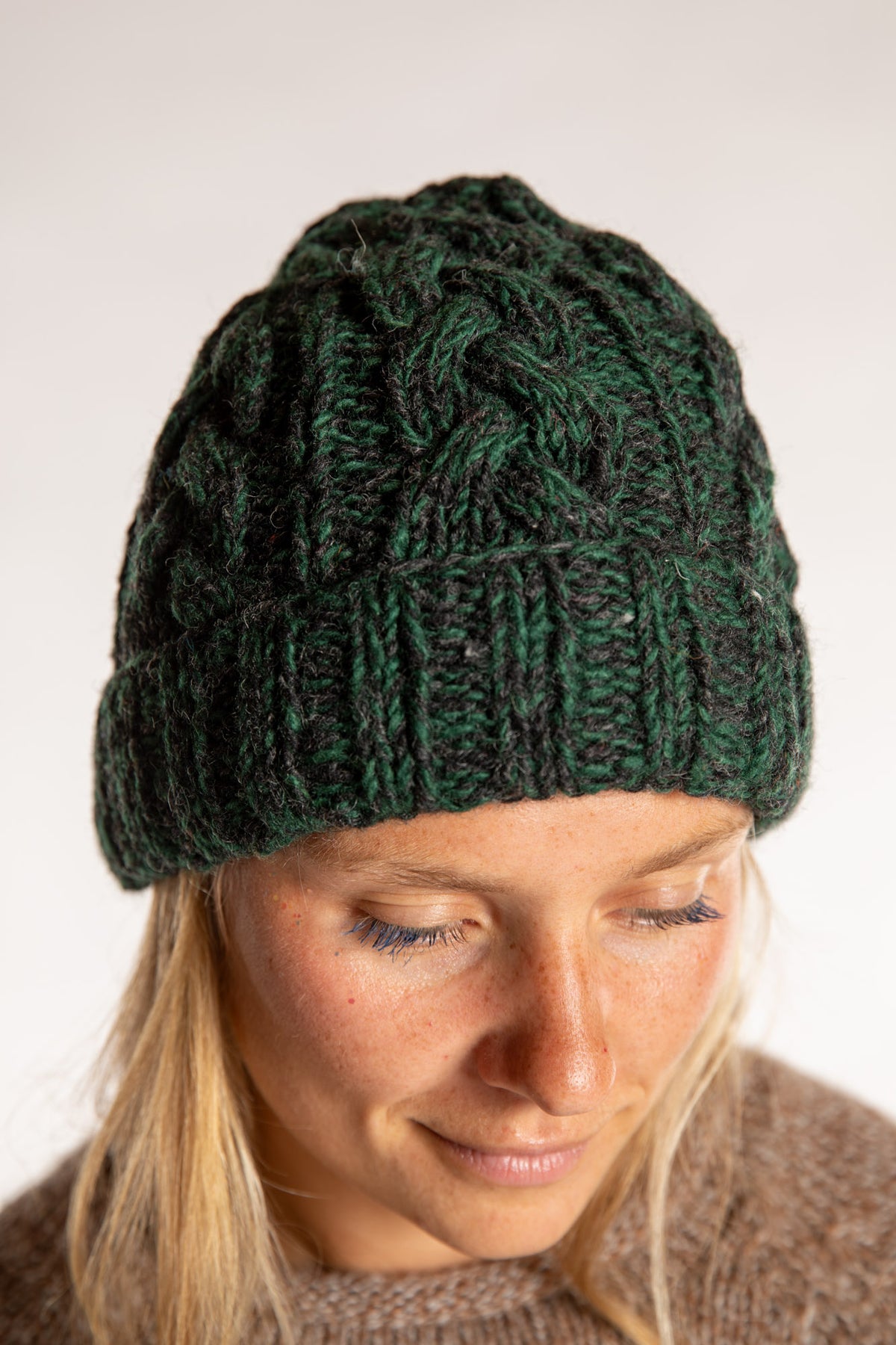 Sophie is wearing the Wharfside Cable Knit Wool Beanie in Forest Green 