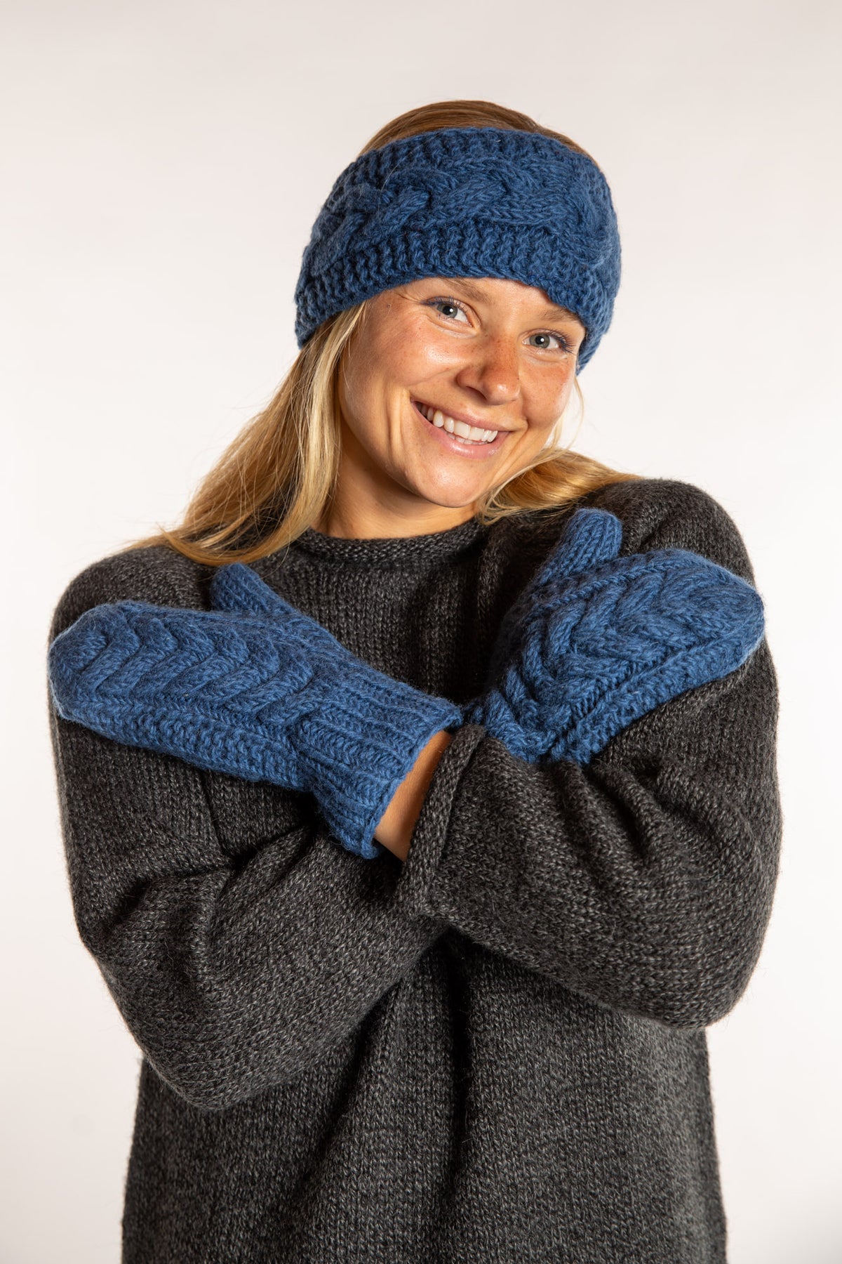Sophie is wearing the Wharfside Cable Knit Wool Mittens in Blue