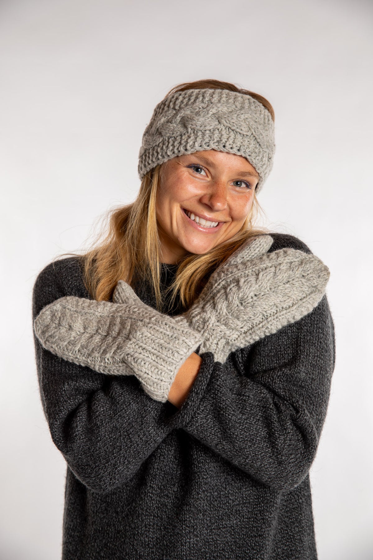 Sophie is wearing the Wharfside Cable Knit Wool Mittens in Mist