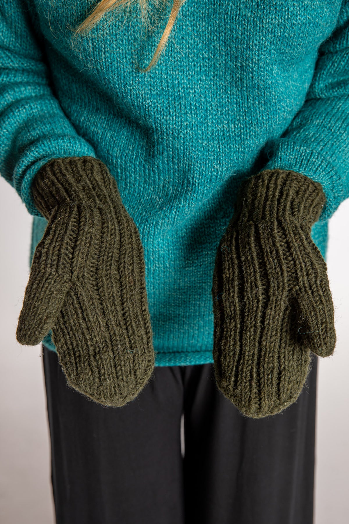 Sophie is wearing the Wharfside Cable Knit Wool Mittens in Olive