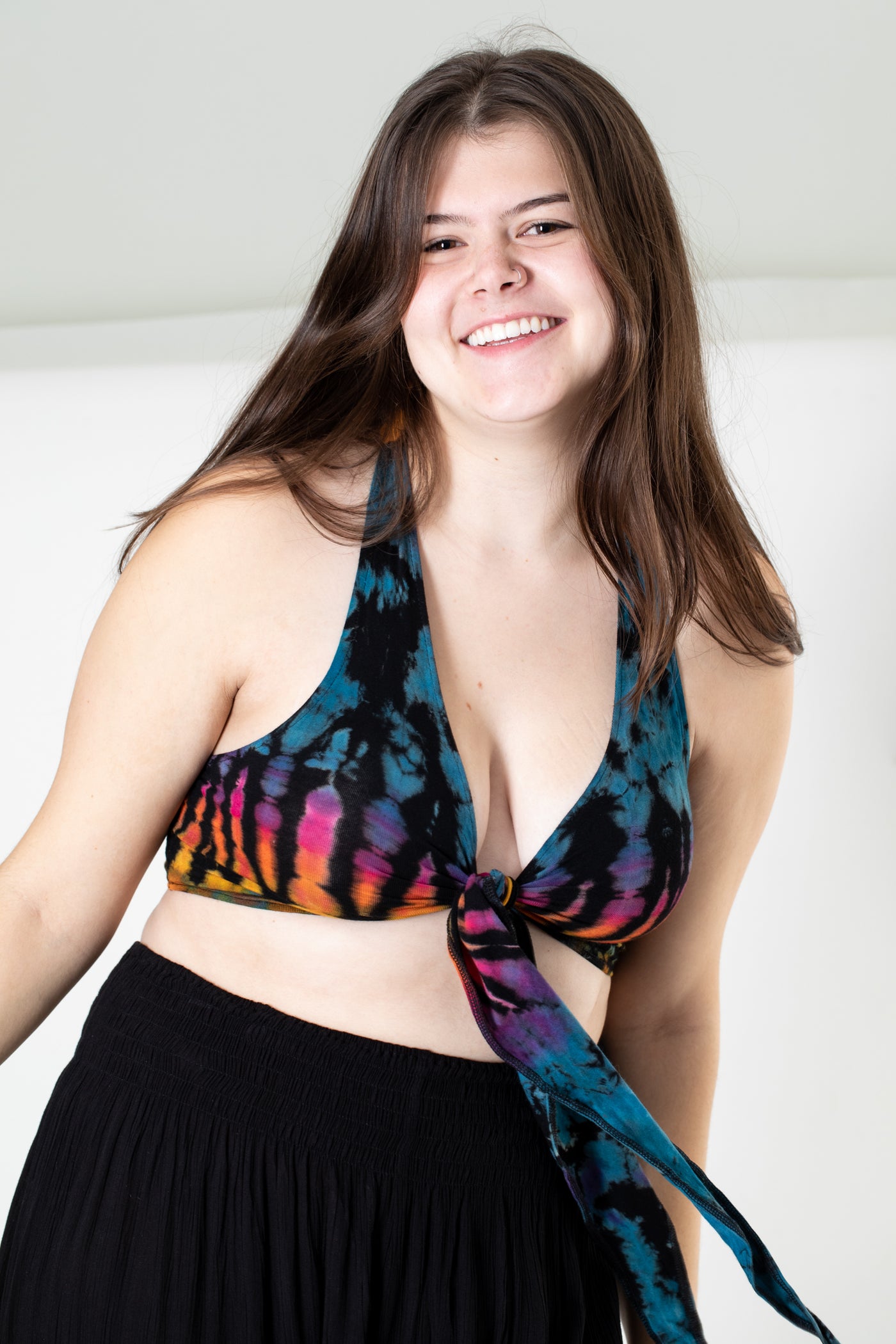 Gabby is wearing a tie dye wrap top in black rainbow 