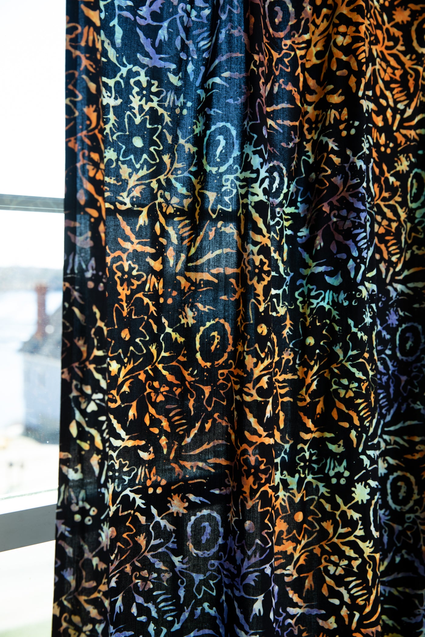 Batik curtain in sunlit shadows