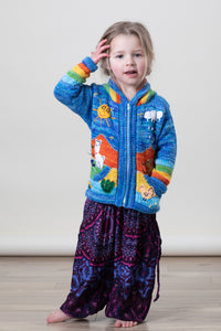 Aurora is wearing a kids nature scene sweater in blue