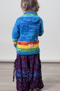 Aurora is wearing a kids nature scene sweater in blue