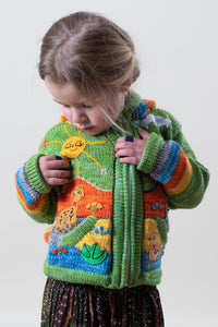 Poppy is wearing a kids nature scene sweater in green