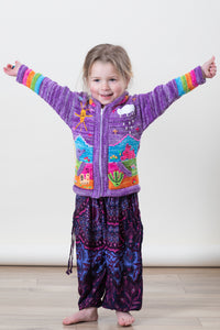 Poppy is wearing a kids nature scene sweater in lavender